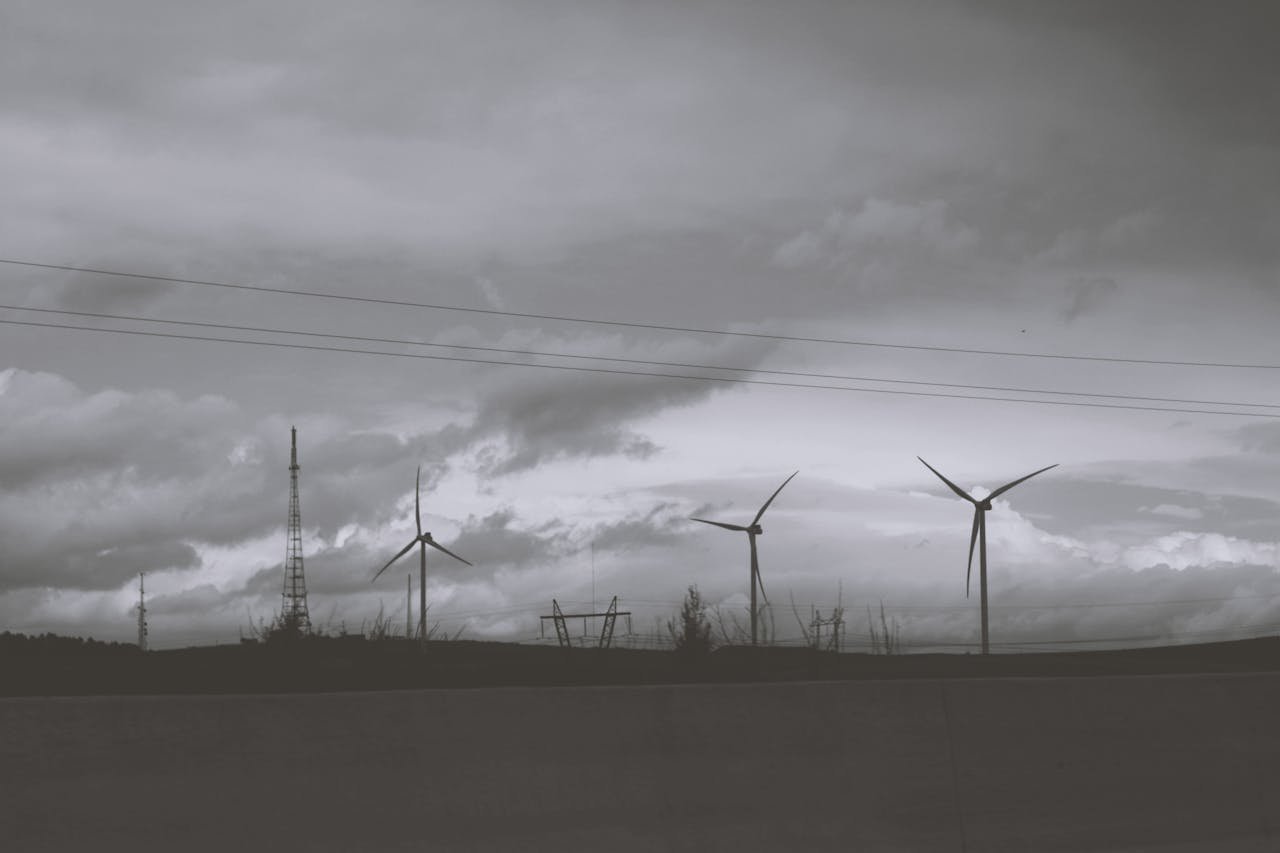 Silhouette of wind turbines against a cloudy sky, symbolizing renewable energy and sustainability.